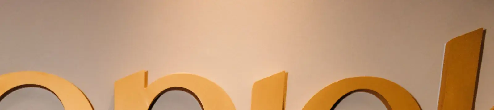 Detalhe das letras douradas com o nome da clínica na parede